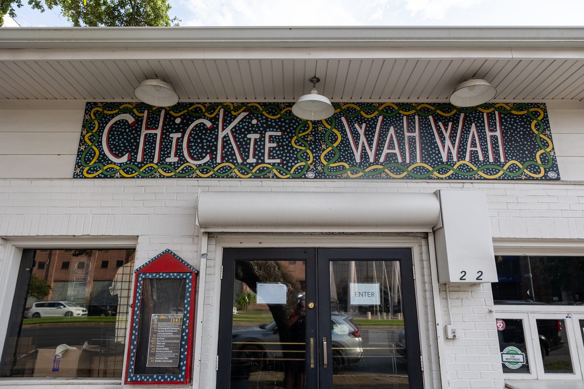 Daytime close-up of the hand-painted Chickie Wah Wah sign above the club's Canal Street entrance